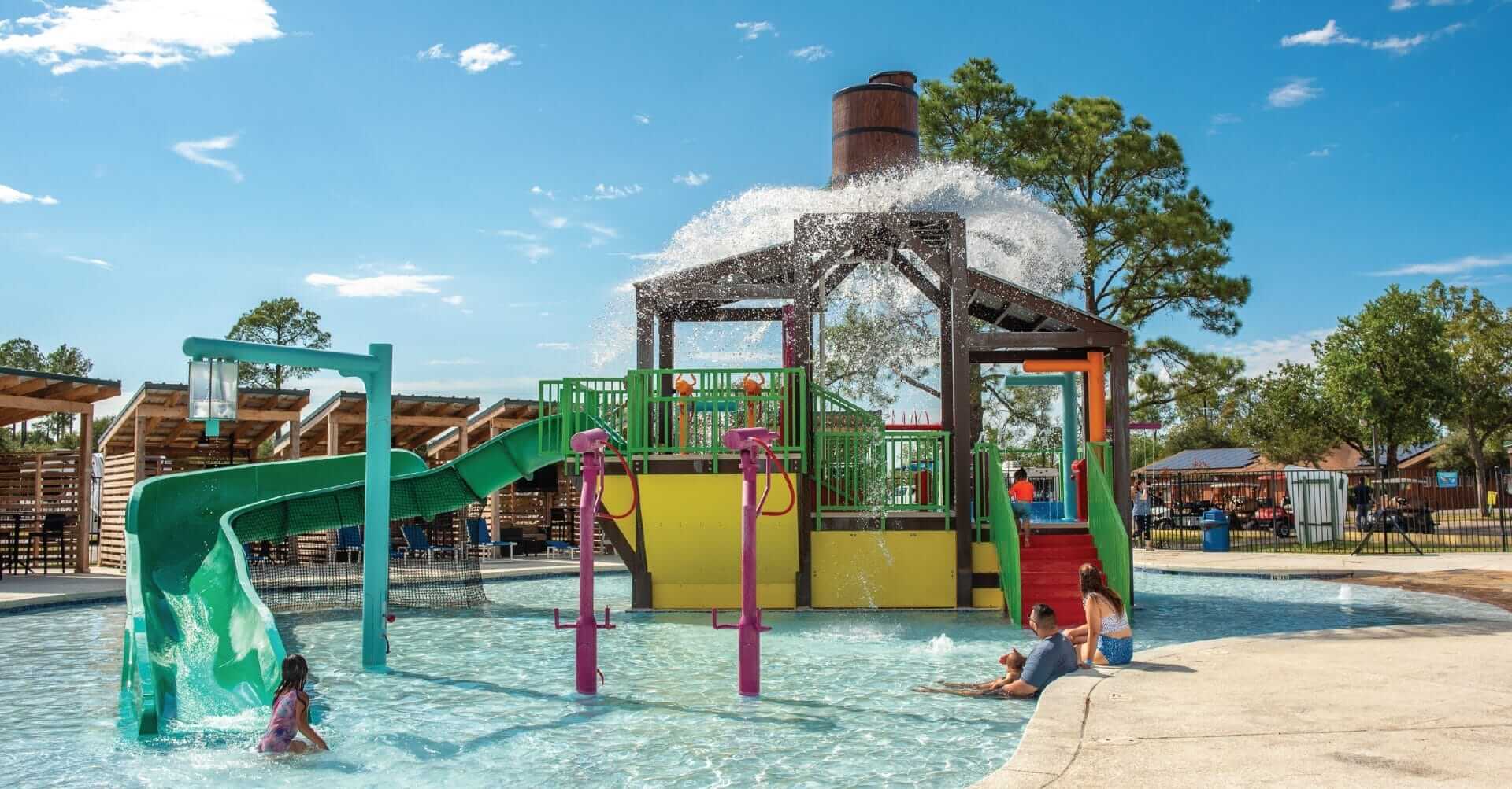 A photo of the aquatic play structure by Interactive play with the power plunge feature releasing a large volume of water at the RV resort in Waller, Texas.
