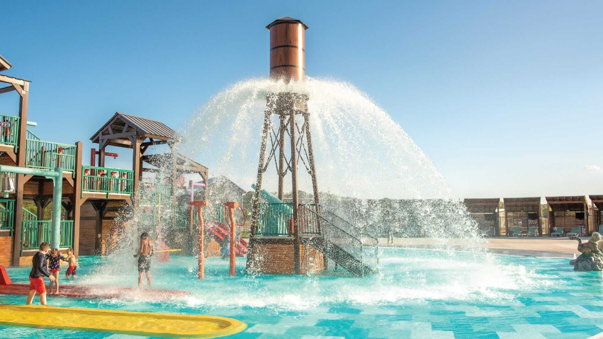 The Power Plunge water feature by Interactive Play releases up to 750 gallons of water in a beautiful 360-degree spray pattern over the pool deck floor at the Camp Fimfo RV Resort in Waco Texas.