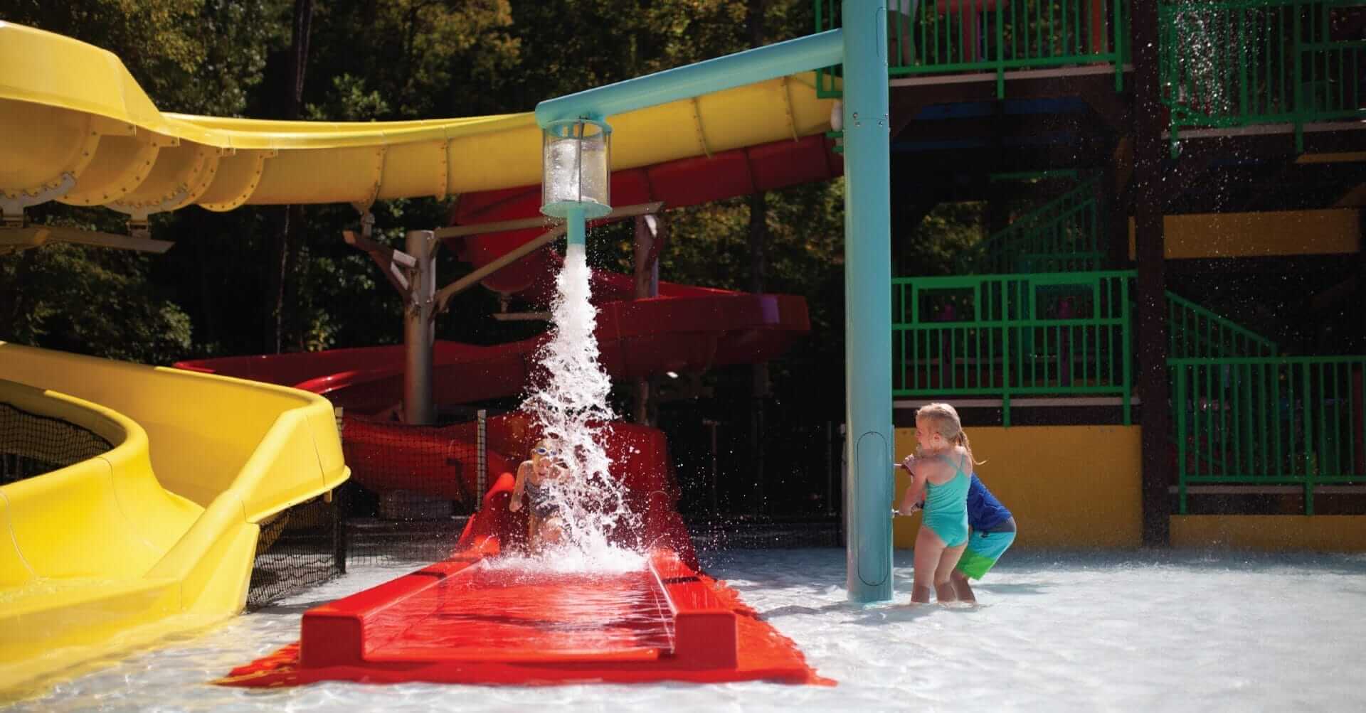 Two young kids activate the pour over water feature at the Jellystone Golden Vally RV Park in Bostic, North Carolina.