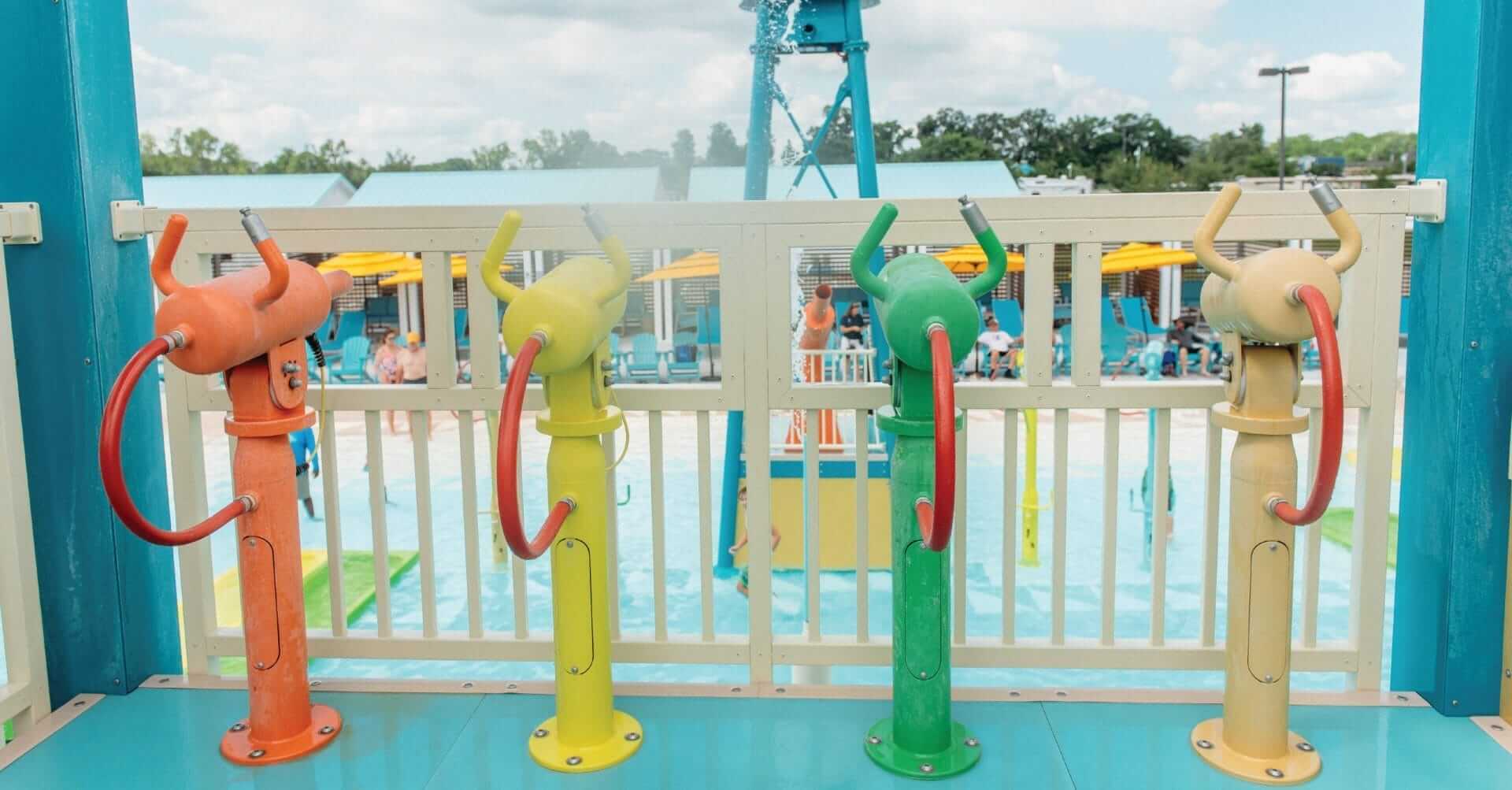 Four Rusher water gun features shown at the waterpark at Camp Margaritaville all in a row in a multi-color pattern.